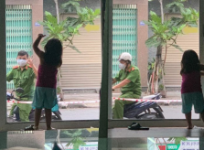 Bố công an vẫy chào con qua cửa kính